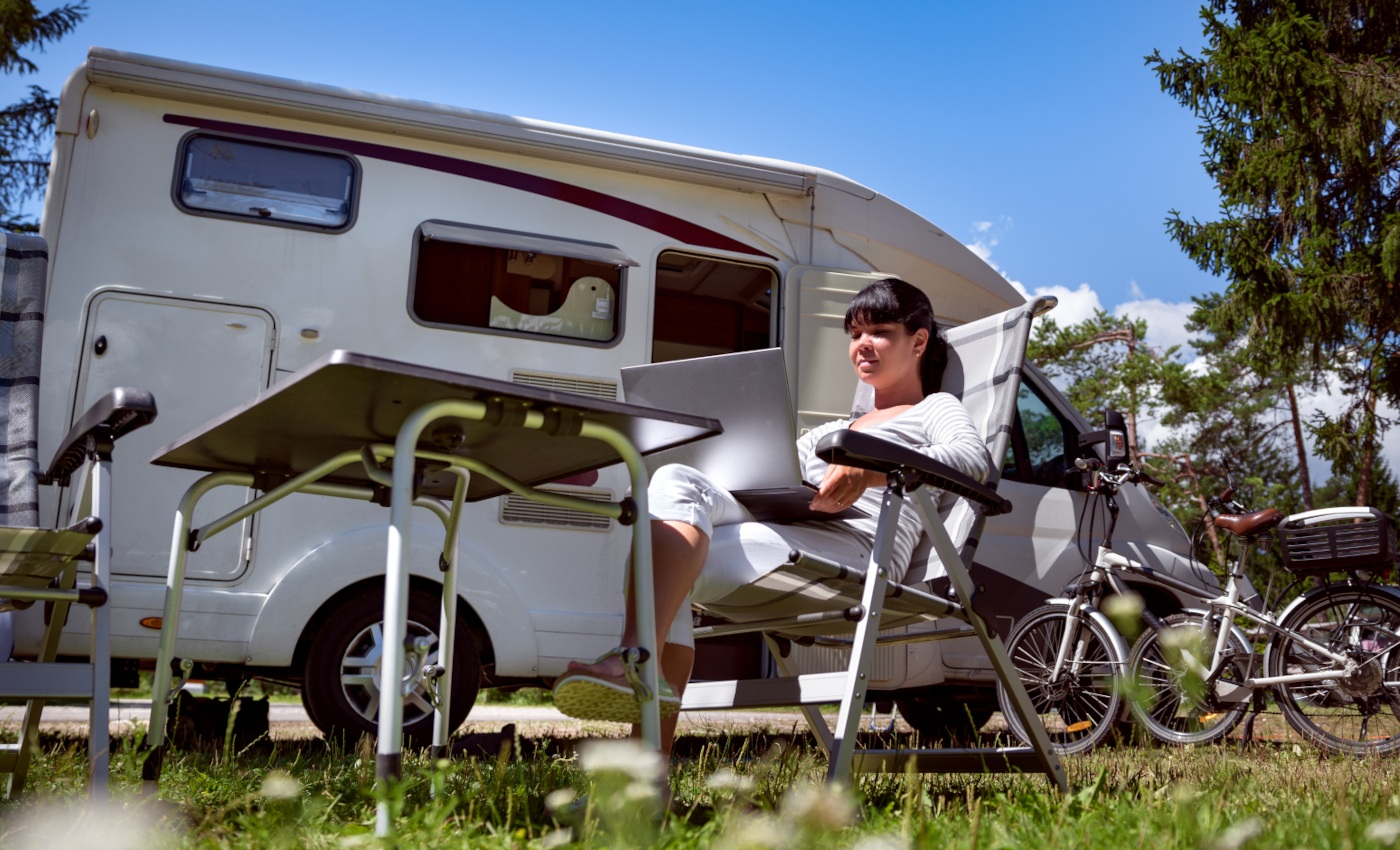 sitting outside a motorhome using laptop to read caravanpro website.